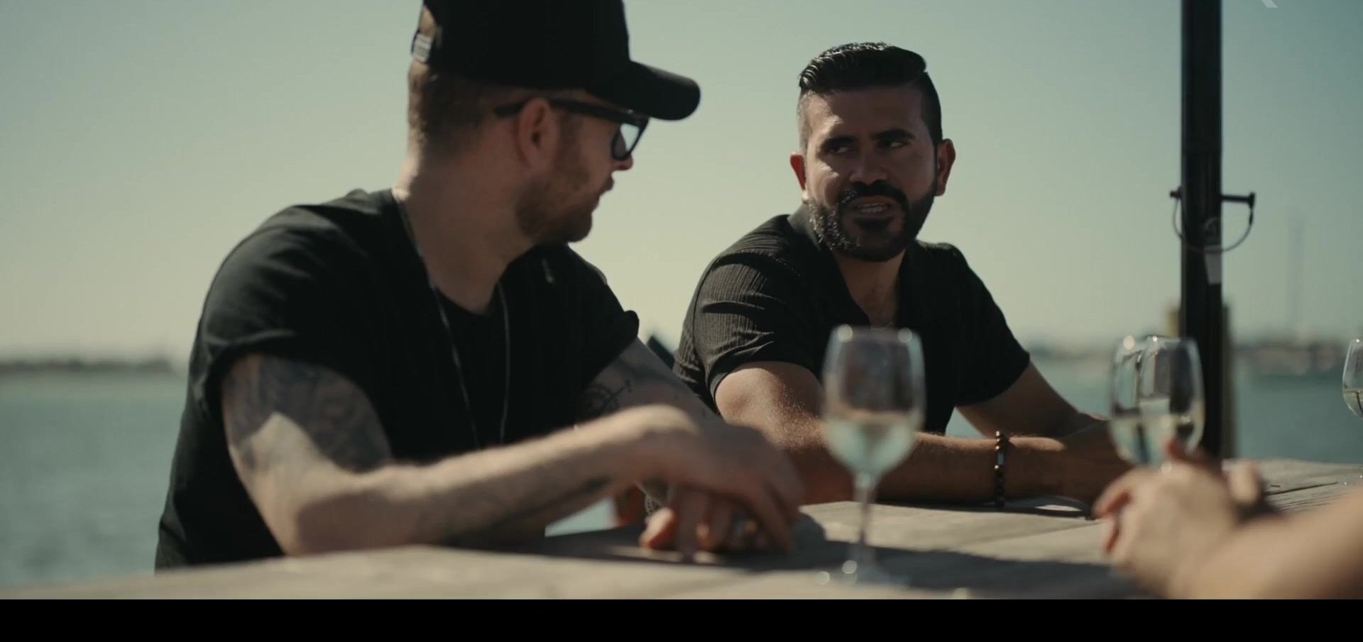 Two of the film's subjects talking at a waterfront table